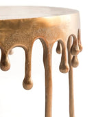 Table with bronze-colored metal drips on a white background