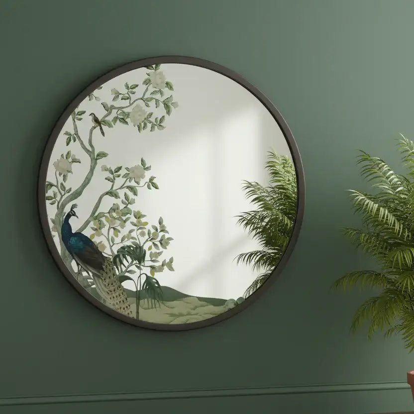 Round decorative mirror with peacock design on a green wall