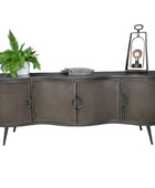 Dark wooden sideboard with a plant, books, and a lantern against a gray wall.