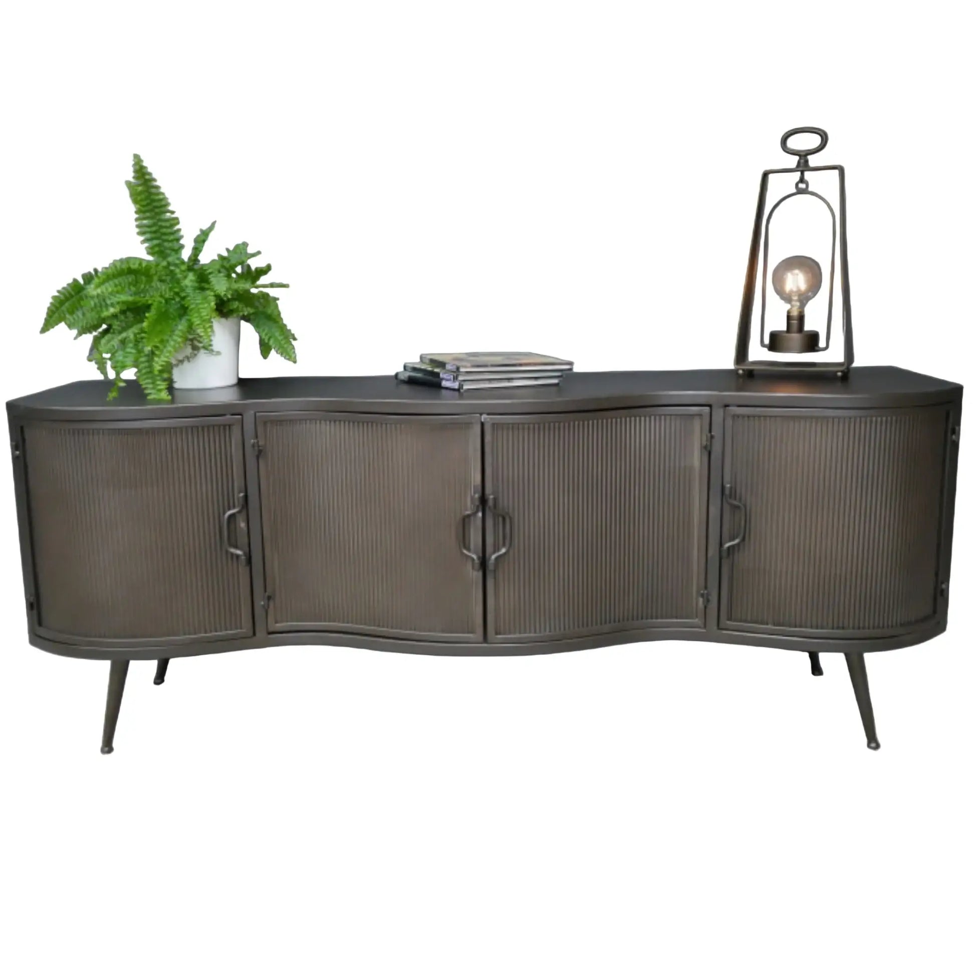 Dark wooden sideboard with a plant, books, and a lantern against a gray wall.