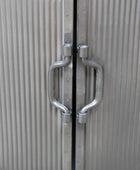 Metallic door with handles on a textured surface