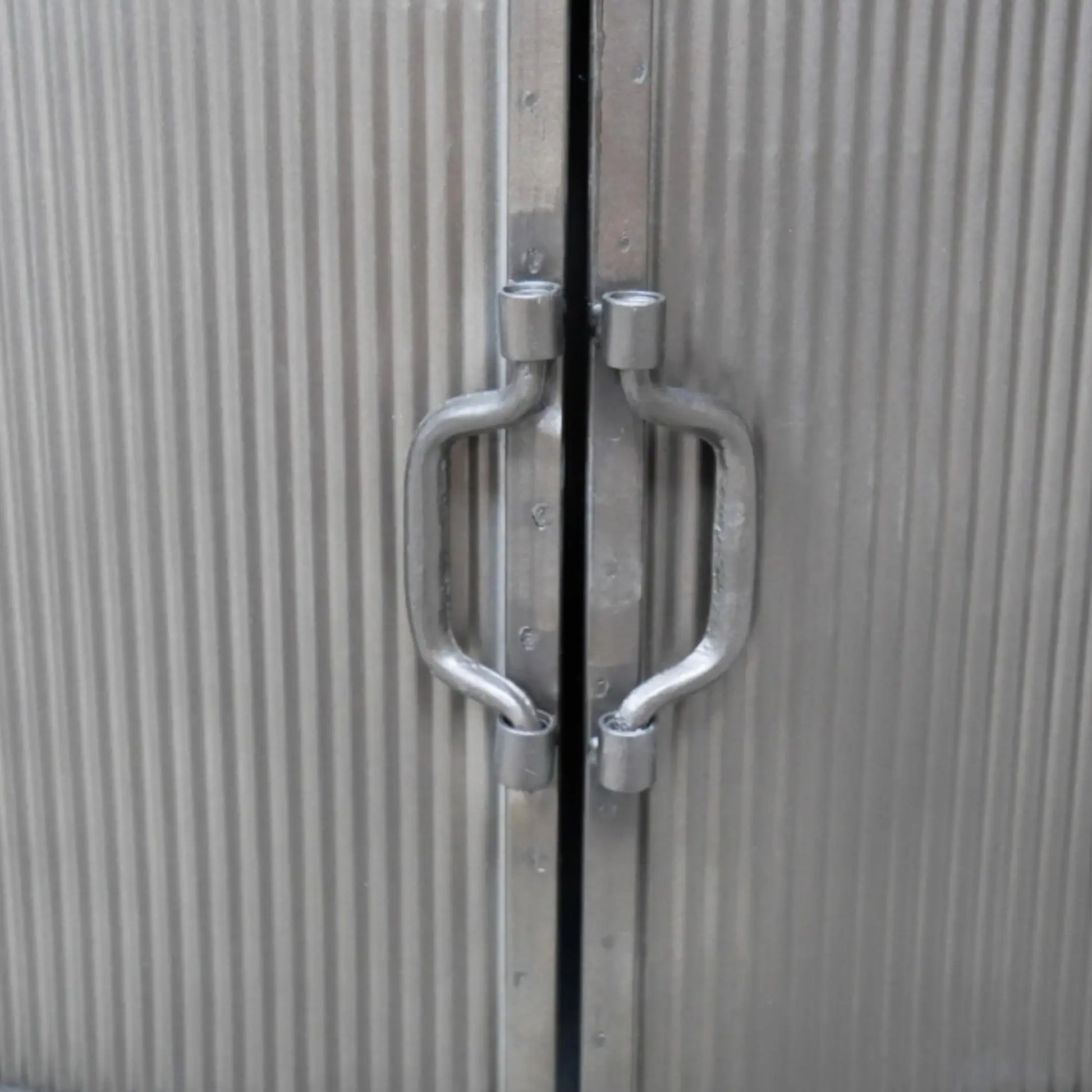 Metallic door with handles on a textured surface