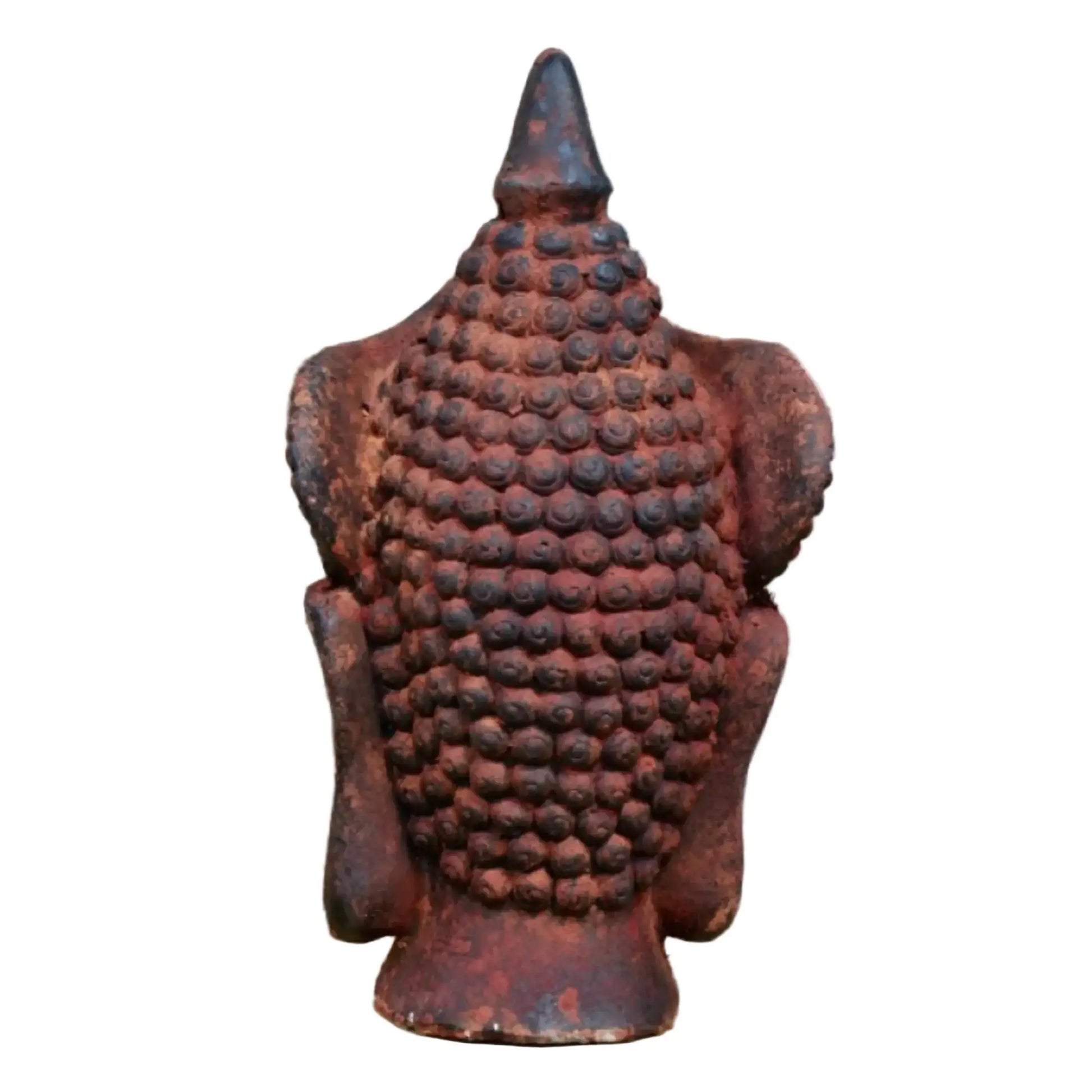 Rust-colored Buddha statue against a stone wall background