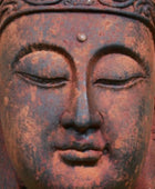 Rust-colored Buddha statue head with intricate details