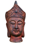 Decorative Buddha head sculpture against a stone wall background