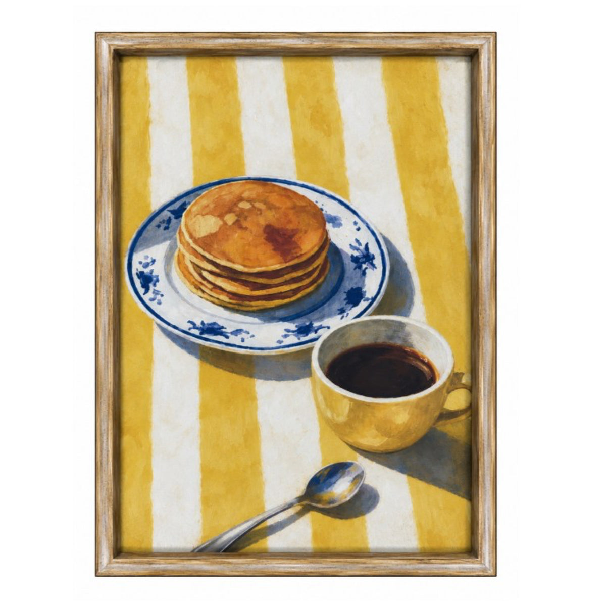 A framed still life painting featuring a stack of pancakes on a blue-and-white plate, a cup of coffee, and a spoon on a yellow-and-white striped table, enclosed in a light wood frame.