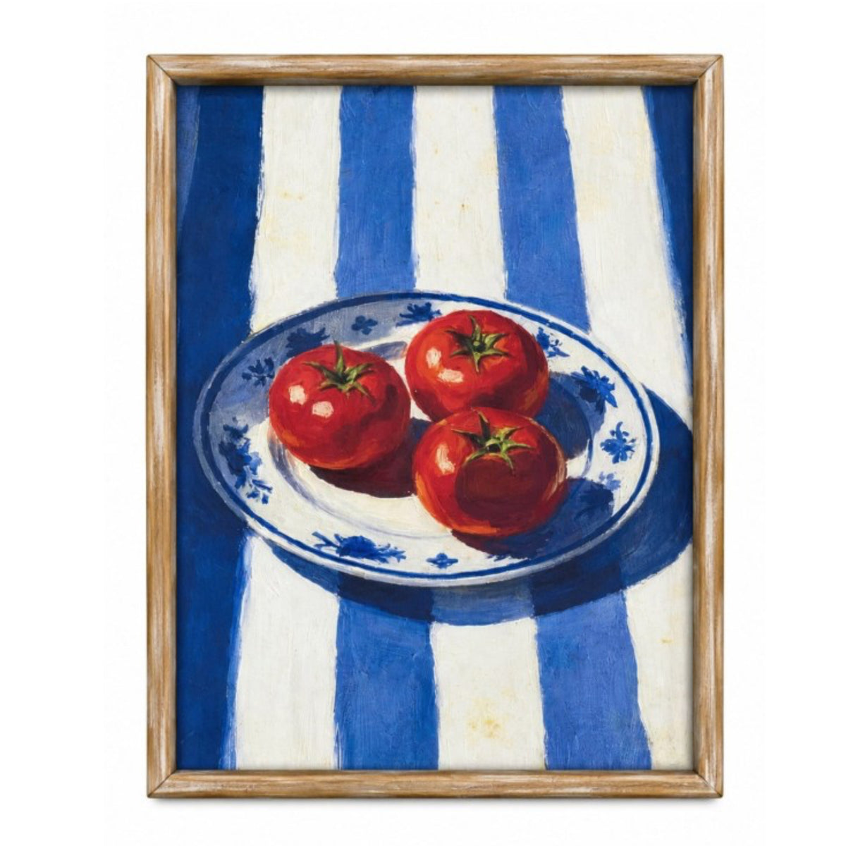 A framed still life painting featuring three red tomatoes on a blue and white patterned plate, set against a blue and white striped background, enclosed in a light wood frame.