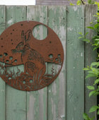 Metal decorative panel with a rabbit design on a wooden fence