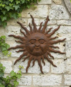 Decorative sun wall art on a stone wall with ivy