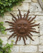 Decorative sun wall art on a stone wall with ivy