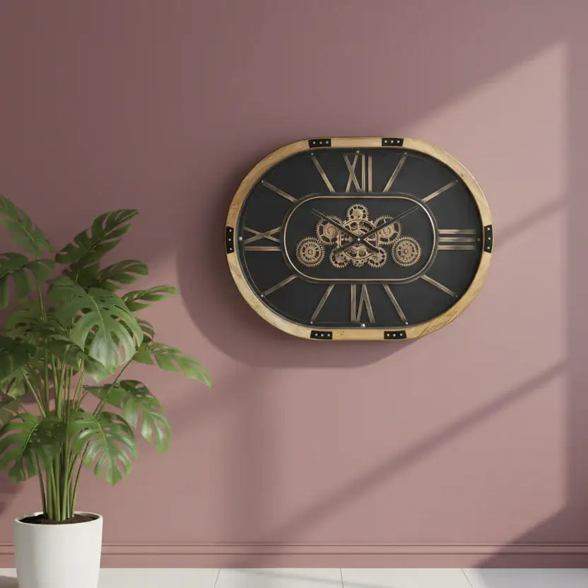 Decorative wall clock with mechanical design on a pink wall next to a potted plant.
