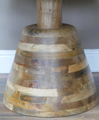 Wooden bell-shaped object on a wooden surface with a neutral background