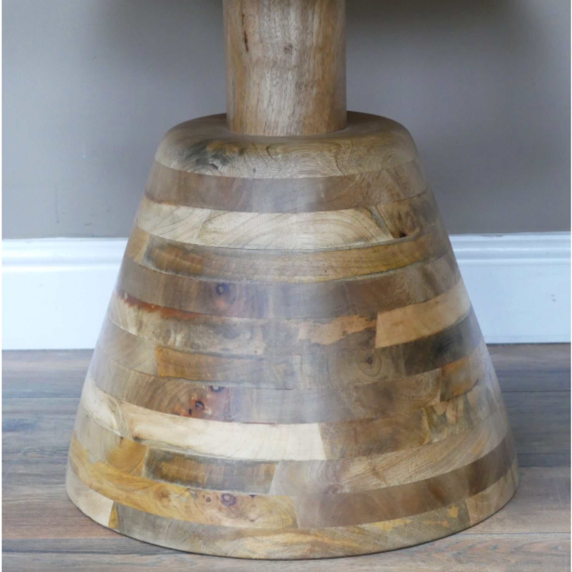 Wooden bell-shaped object on a wooden surface with a neutral background
