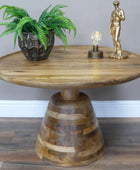 Wooden side table with a plant, lamp, and statue on a gray wall background
