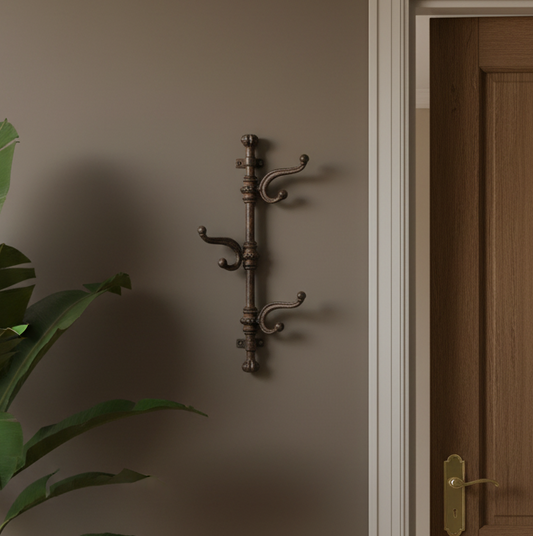 Decorative wall hook on a brown wall with a plant and wooden door in the background
