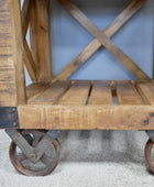 Wooden cart with metal wheels on a light gray surface