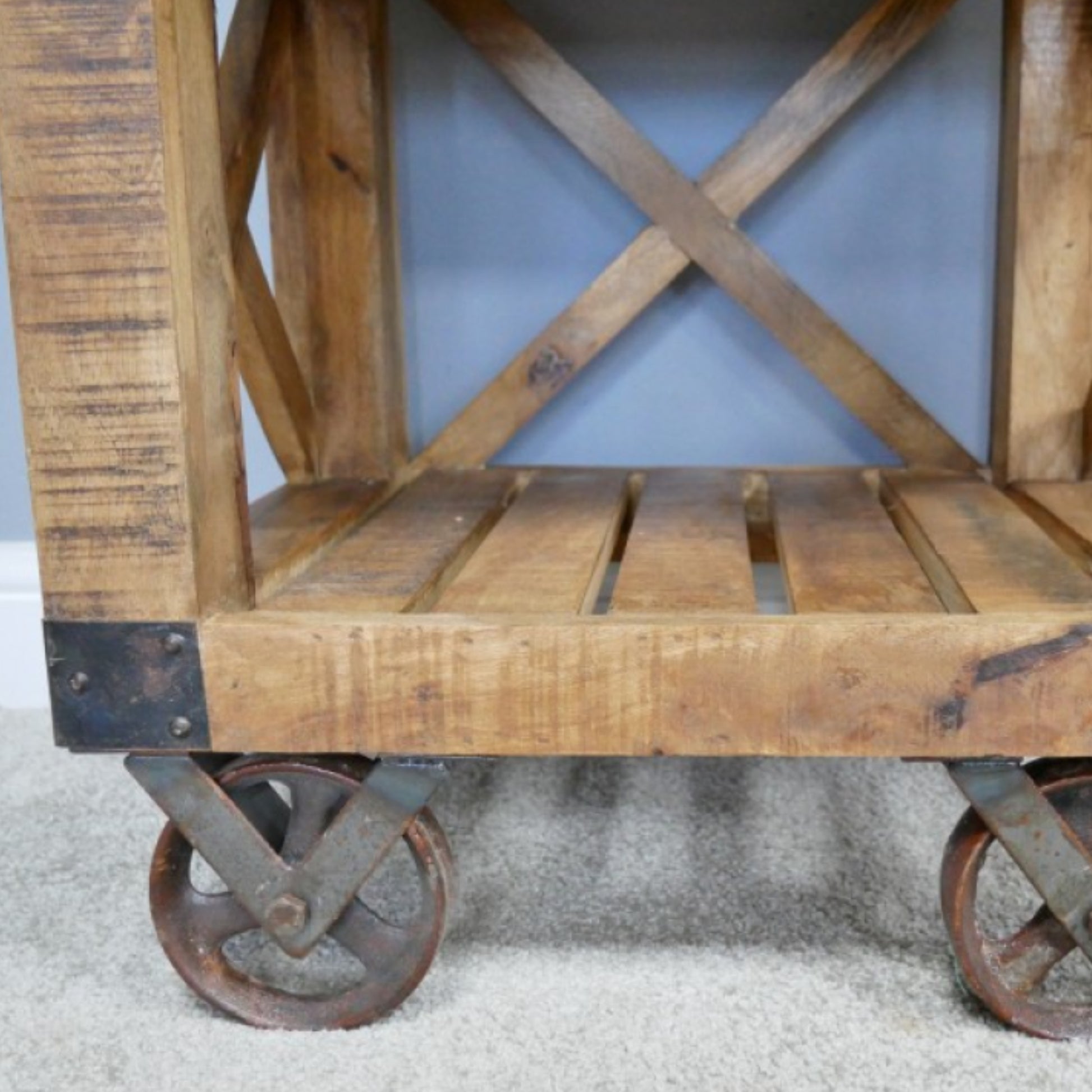Wooden cart with metal wheels on a light gray surface