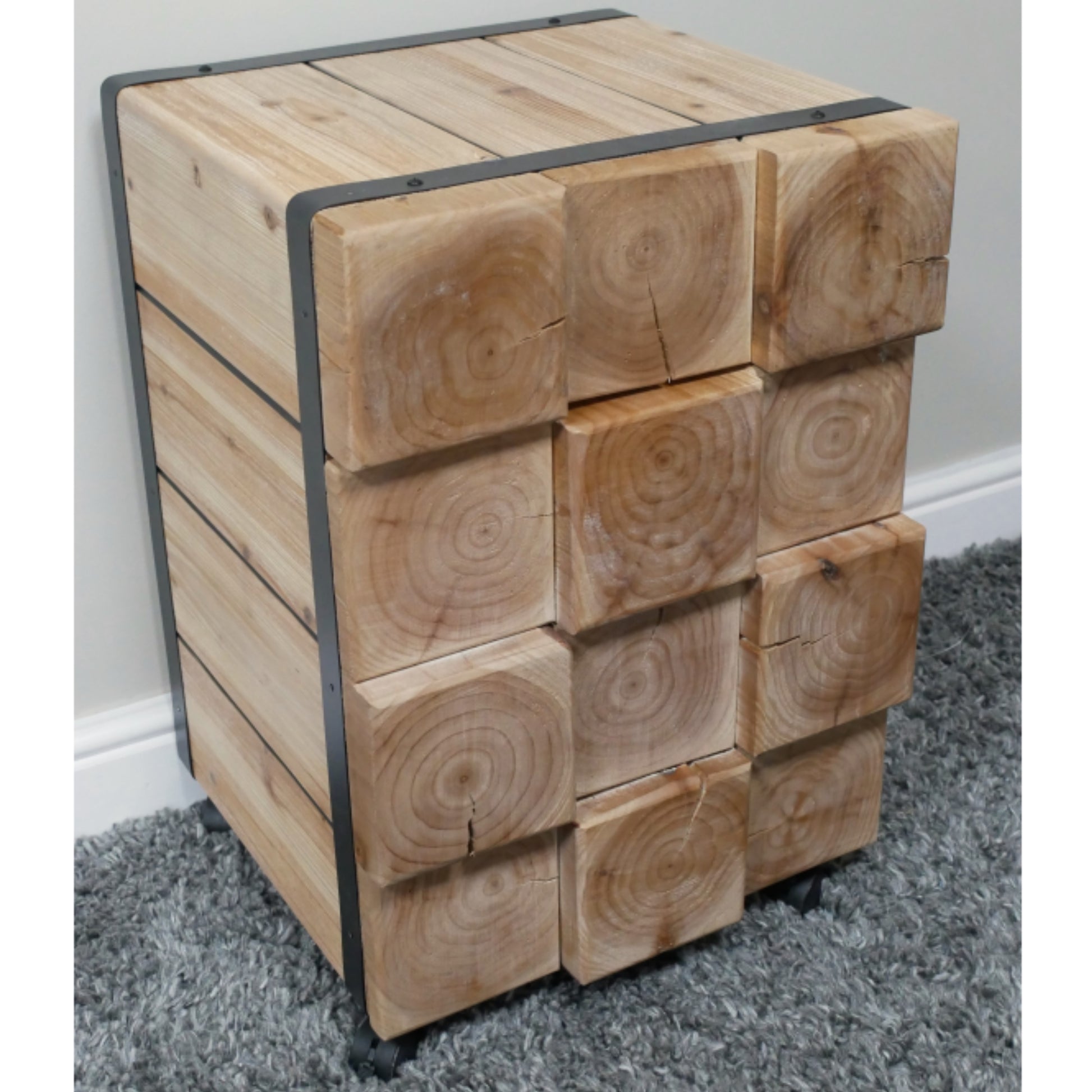 Wooden cube-shaped side table with metal frame on a gray carpet