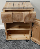 Wooden storage unit with a door open on a gray carpeted floor.