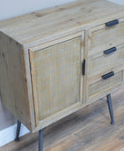 Wooden cabinet with rattan door and metal legs on a wooden floor.