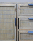 Wooden cabinet with woven design and blue handles on a light gray background