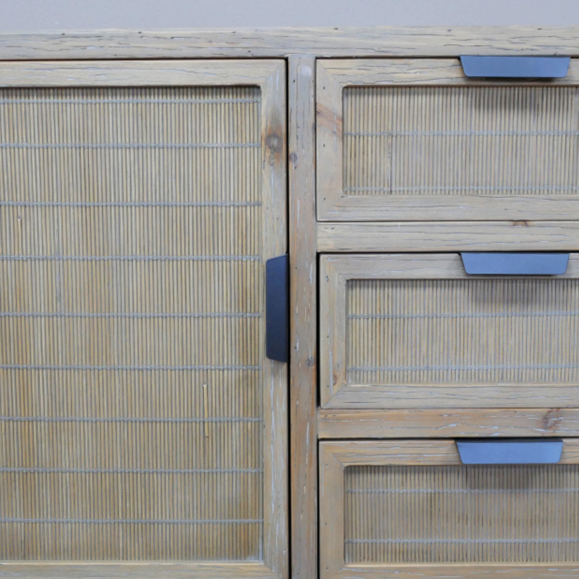 Wooden cabinet with woven design and blue handles on a light gray background