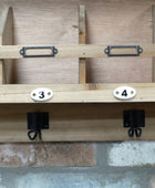 Wooden shelf with brackets and numbers on a concrete floor