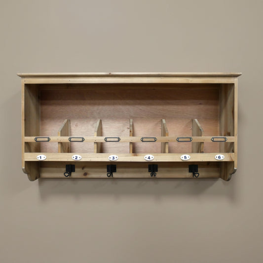 Wooden wall-mounted rack with numbered hooks on a beige wall.