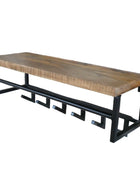 Wooden bench with black metal frame against a brick wall