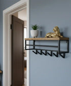 Wall-mounted shelf with wooden top and metal hooks against a light blue wall.