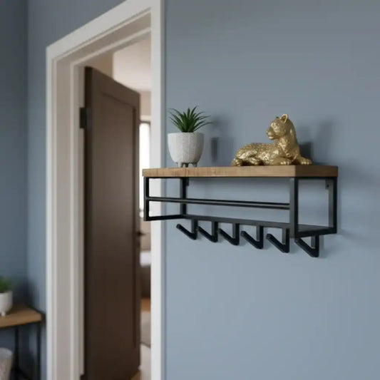 Wall-mounted shelf with wooden top and metal hooks against a light blue wall.