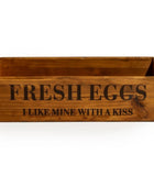 Wooden crate with 'Fresh Eggs I Like Mine With A Kiss' text on a white background