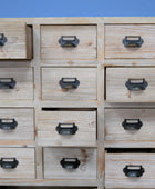 Wooden drawer unit with metal handles against a blue background