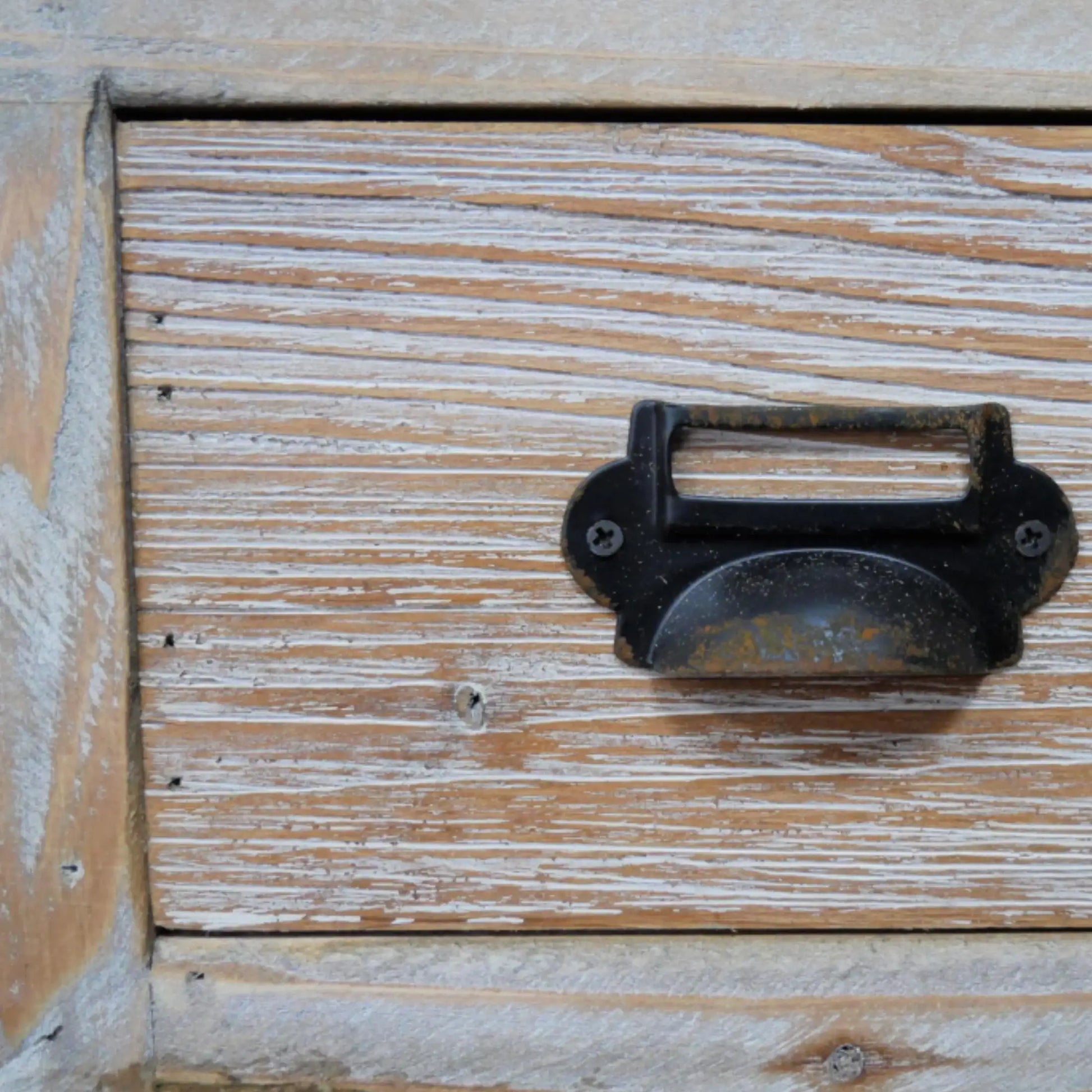 Wooden drawer with a metal handle showing signs of wear.