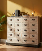 Wooden dresser with multiple drawers against a yellow wall with a plant on the left.