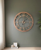 Large wooden wall clock with Roman numerals on a gray background