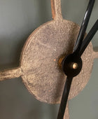 Close-up of a clock mechanism with a metallic finish on a gray background
