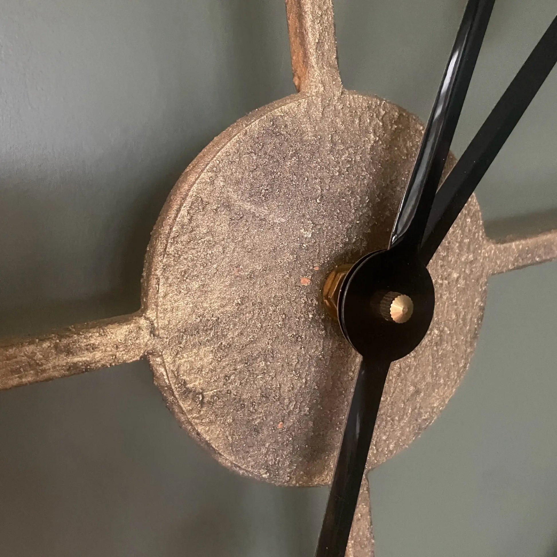 Close-up of a clock mechanism with a metallic finish on a gray background