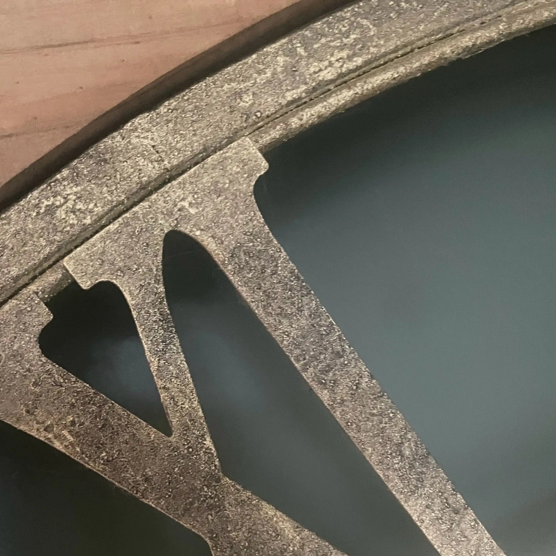 Close-up of a concrete block with water and wood in the background
