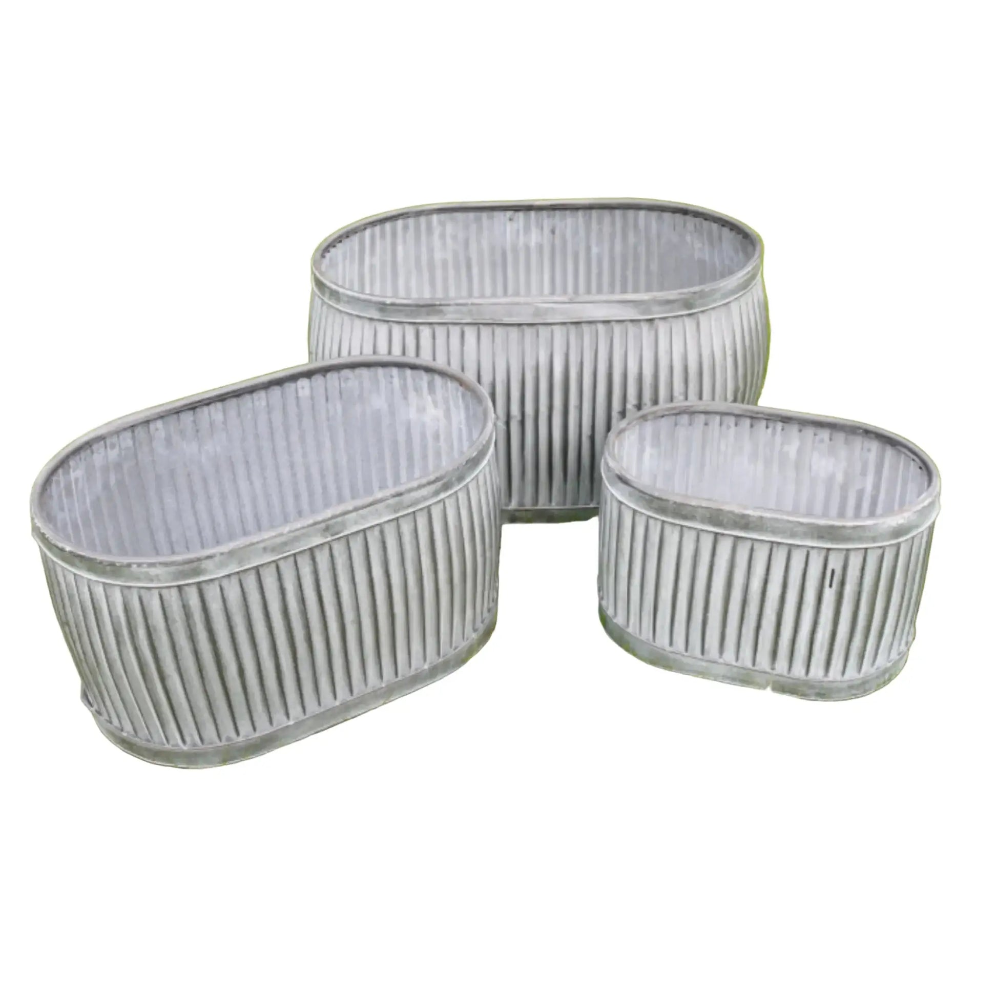 Three galvanized metal planters of different sizes on a grassy background