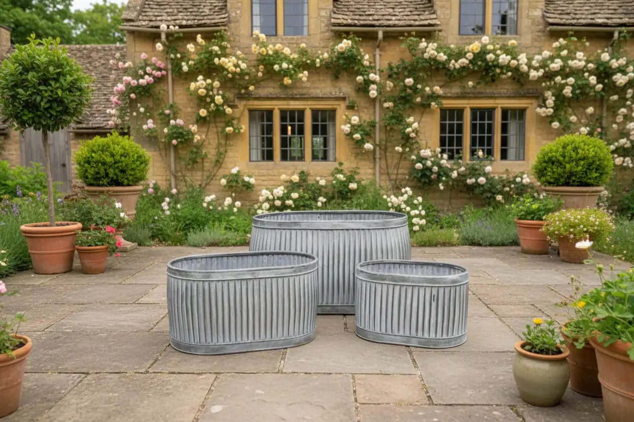 Decorative garden with stone patio, potted plants, and a house with floral climbing plants.