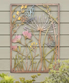 Decorative metal wall art with floral and butterfly design on a wooden wall.