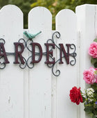 Decorative 'Garden' sign on a white picket fence with flowers.