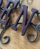 Decorative metal letters 'B' and 'V' on a wooden surface