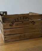 Wooden crate with 'Sweet Fruits' branding on a wooden floor.