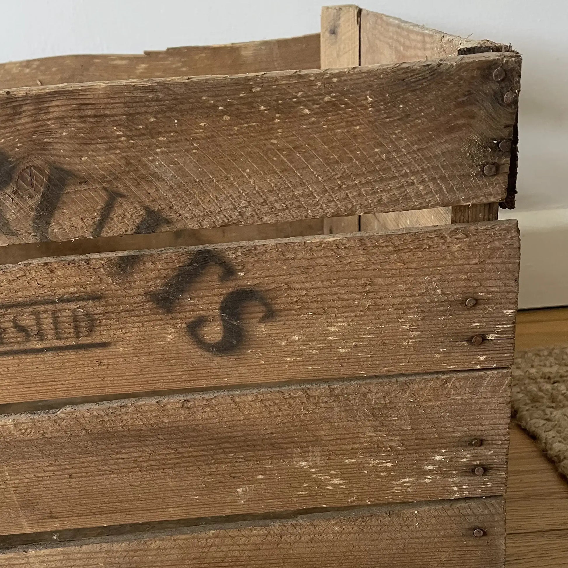 Close-up of a wooden crate with visible branding on a neutral background