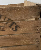 Close-up of a wooden crate with visible branding on a neutral background