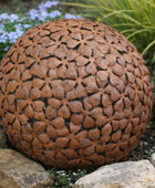 Decorative brown spherical object with floral pattern on a garden background