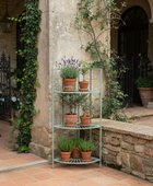 Outdoor patio with stone walls, potted plants, and a metal shelf.
