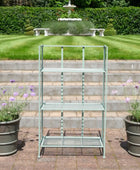 Metal garden shelf with plants on a patio area in front of a fountain.